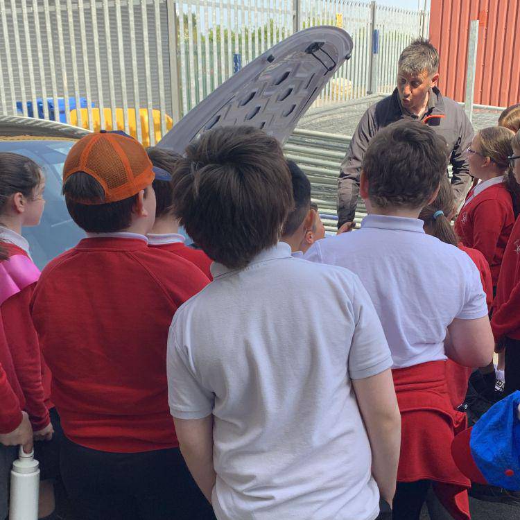 Coleg Llandrillo engineering lecturer Arron Peel showing Ysgol Emmanuel pupils a Tesla at the Rhyl campus