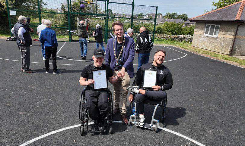 Former Coleg Menai students Ryan and Kieran Jones on the new basketball court at Parc Mwd with Councillor Neil Tuck