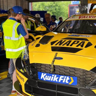 Coleg Menai motorsport engineering students looking at a NAPA Racing UK car at Oulton Park race track