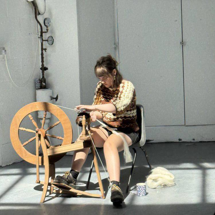 Cadi Richardson yn gweithio wrth olwyn droelli yn stiwdio Celf a Dylunio Coleg Menai