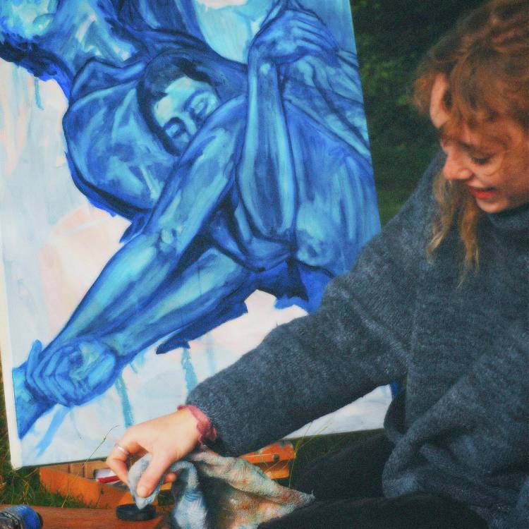 Cyn-fyfyrwraig o Goleg Menai, Maisy Lovatt, yn gweithio ar baentiad