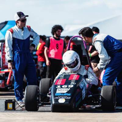 Y gyrrwr a'r tîm cefnogi gyda char myfyrwyr Kingston Racing