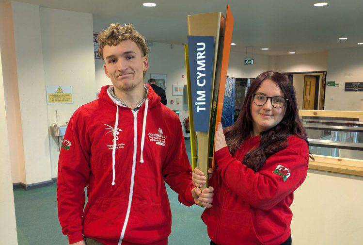 Myfyrwyr peirianneg Coleg Menai, Oliver Weldon a Connie Whitfield, yn dal fflam Tîm Cymru