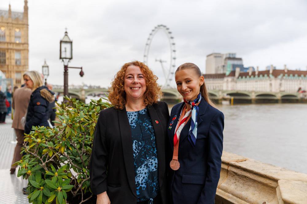 Myfyrwraig o Goleg Llandrillo, Yuliia Batrak gyda'r AS, Gill German ger Afon Tafwys gyda'r London Eye yn y cefndir