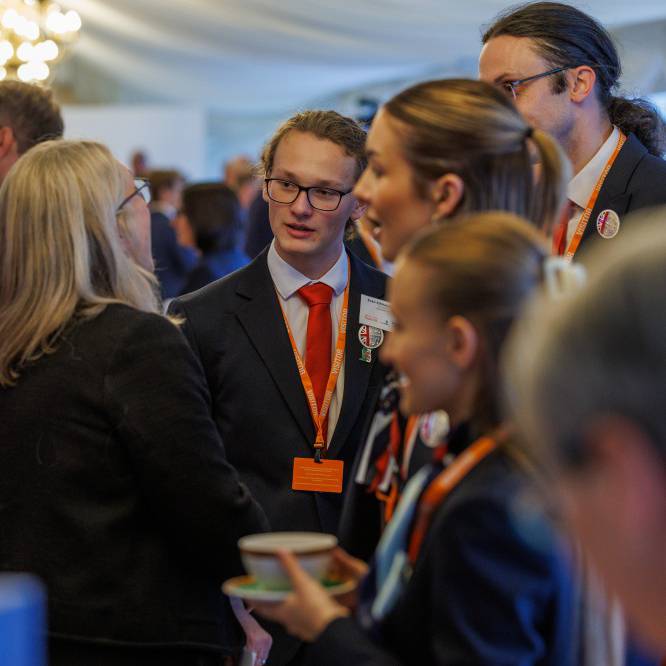 Myfyriwr o Goleg Menai, Evan Klimaszewski, yn siarad â gwesteion eraill mewn derbyniad ar gyfer cystadleuwyr EuroSkills yn Nhŷ'r Cyffredin