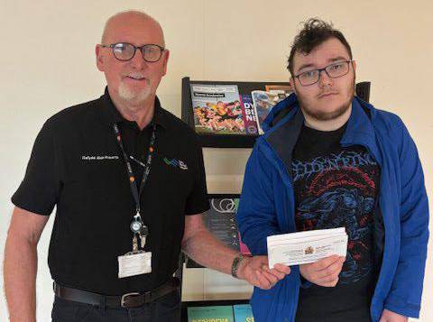 Coleg Menai student Kenan Davies-Zorlu with a letter confirming his WLCOW Award, with tutor Dafydd Alun Roberts