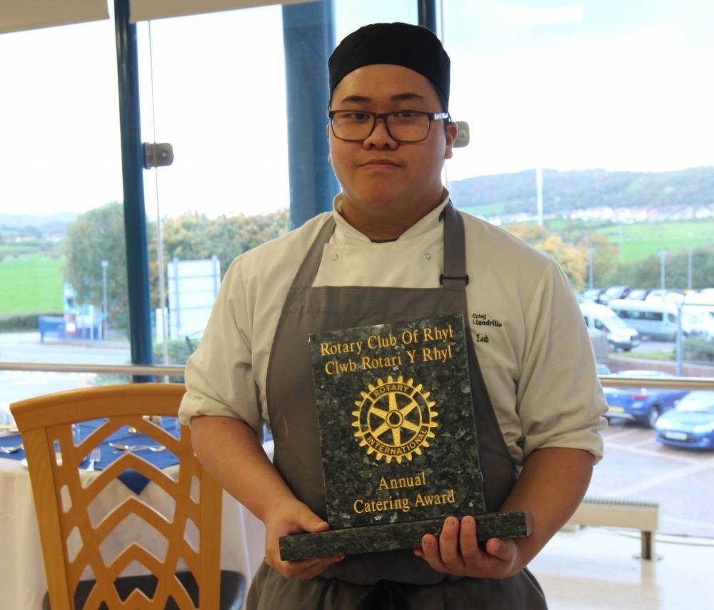 Hugo Loh gyda'i dlws ym mwyty Orme View Coleg Llandrillo ar ôl iddo ennill Gwobr Arlwyo flynyddol Clwb Rotari y Rhyl