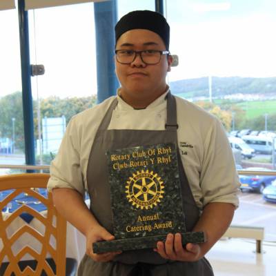 Hugo Loh gyda'i dlws ym mwyty Orme View Coleg Llandrillo ar ôl iddo ennill Gwobr Arlwyo flynyddol Clwb Rotari y Rhyl