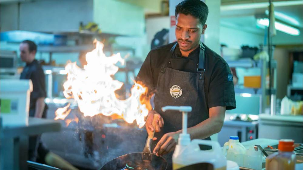 Cogydd (chef) yn coginio yn y gegin