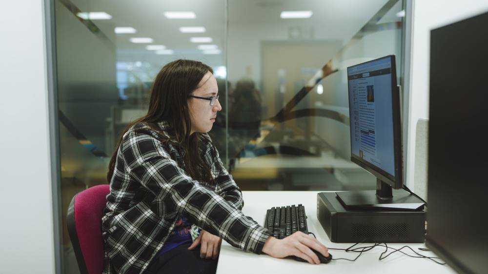 A learner working on a computer in the library