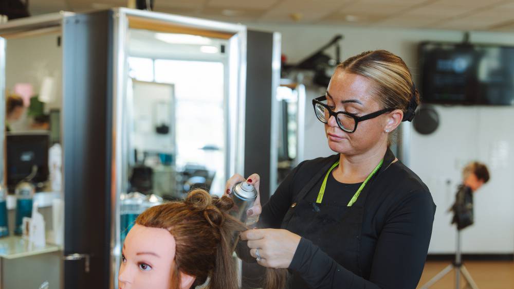 Myfyriwr trin gwallt yn torri gwallt