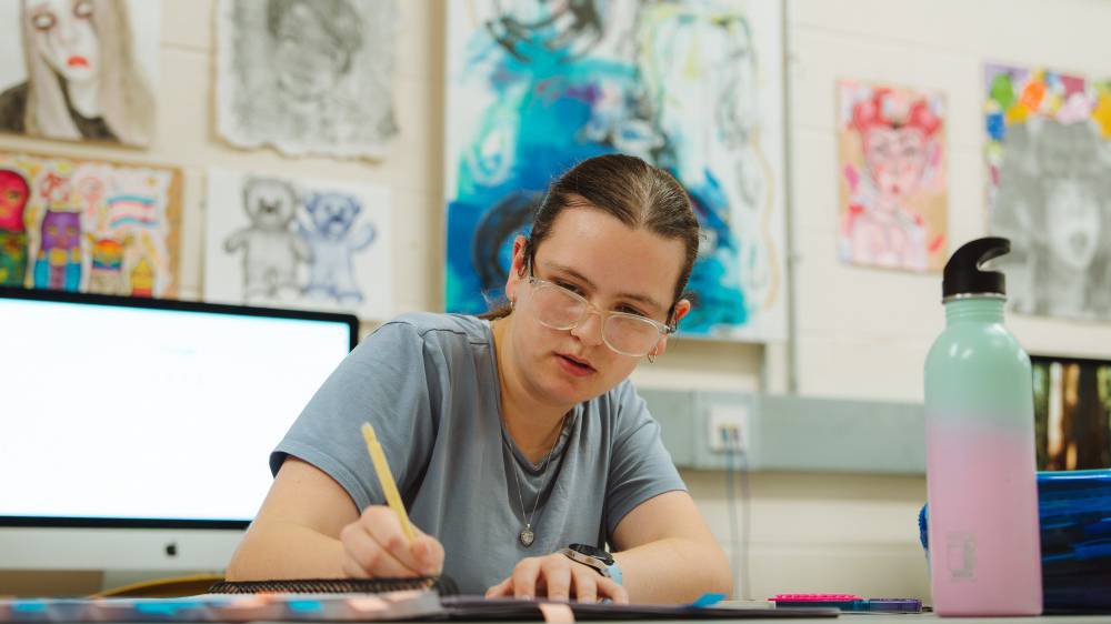 Myfyriwr celf yn gweithio yn y stiwdio