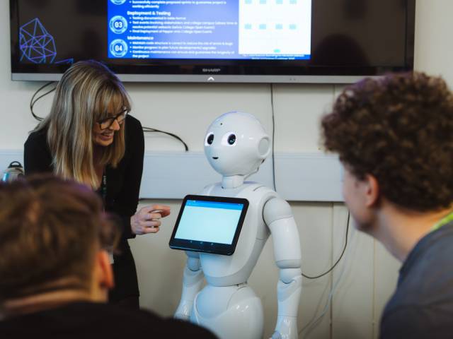 Lecturer teaching learners about AI and robotics