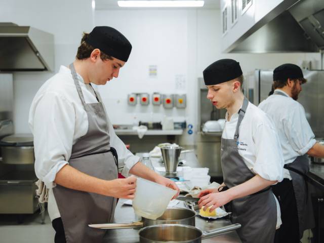 Two learners cooking in the kitchen