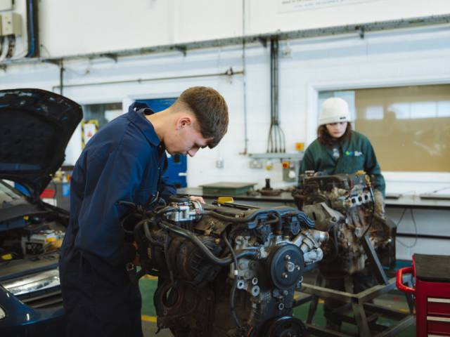 Dysgwr yn gweithio ar injan car