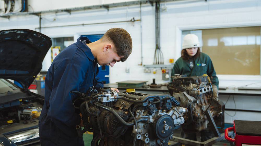 Dysgwr yn gweithio ar injan car