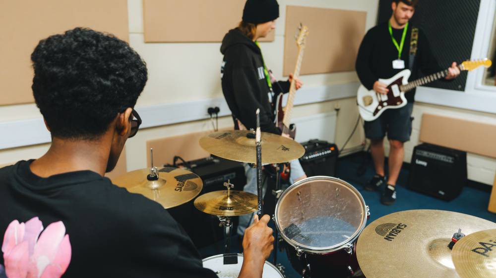 Dysgwyr cerdd yn chwarae mewn band