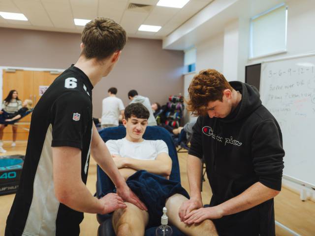 Learners practicing a sports massage