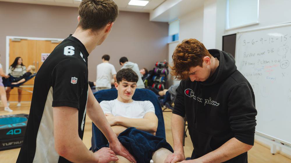 Learners practicing a sports massage
