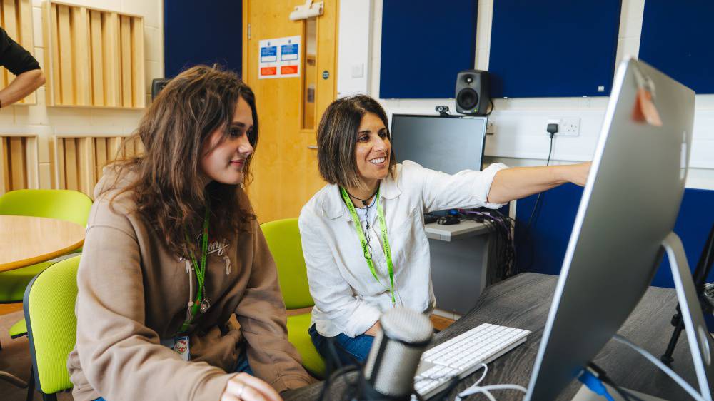 Two female learners working on an iMac