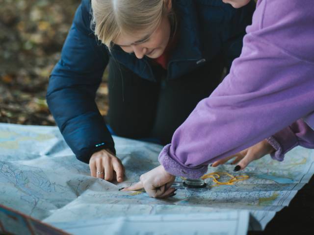 Learners reading a map outdoors